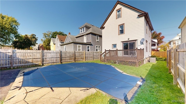 view of pool with a lawn and a wooden deck