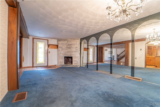 unfurnished living room featuring a stone fireplace and carpet