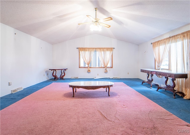 rec room featuring a textured ceiling, dark colored carpet, lofted ceiling, and ceiling fan