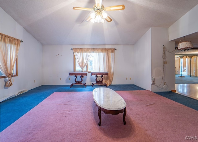 misc room featuring ceiling fan, dark colored carpet, a textured ceiling, and vaulted ceiling