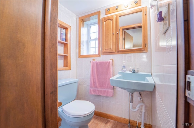 bathroom with toilet, tile walls, hardwood / wood-style floors, and crown molding