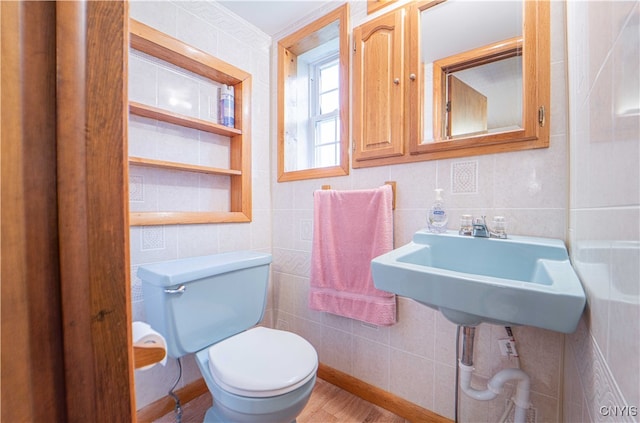 bathroom with hardwood / wood-style floors, toilet, and tile walls