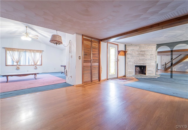 unfurnished living room with hardwood / wood-style floors, plenty of natural light, and lofted ceiling with beams