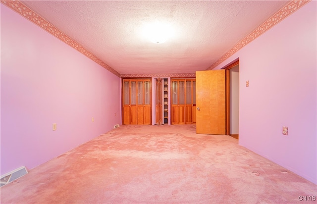 carpeted spare room featuring a textured ceiling