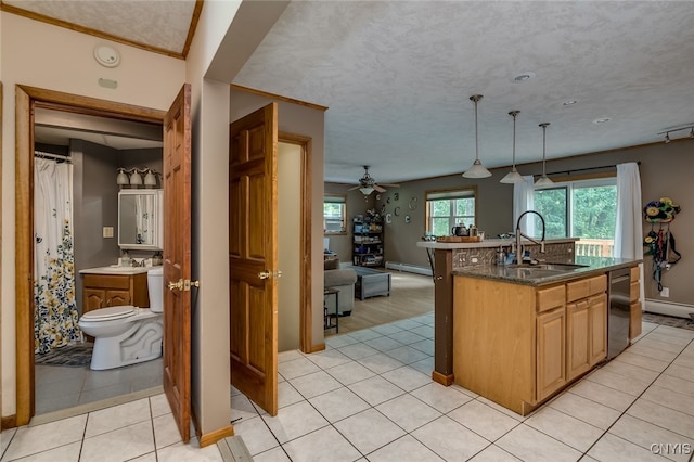 kitchen with an island with sink, hanging light fixtures, a textured ceiling, and light tile patterned floors