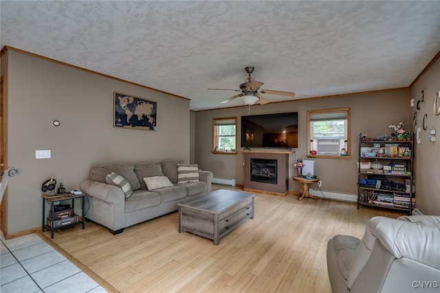 living room featuring baseboard heating, a textured ceiling, and light wood-type flooring