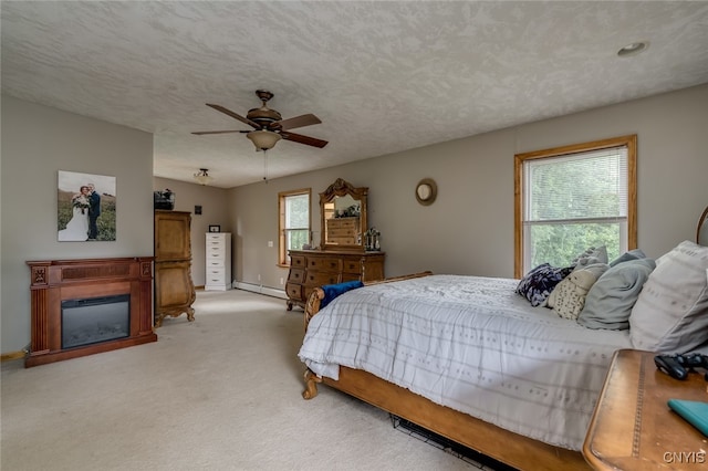 carpeted bedroom with a textured ceiling, baseboard heating, and ceiling fan