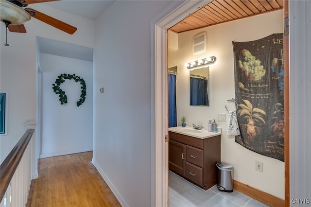 hallway featuring wooden ceiling, light hardwood / wood-style floors, and sink