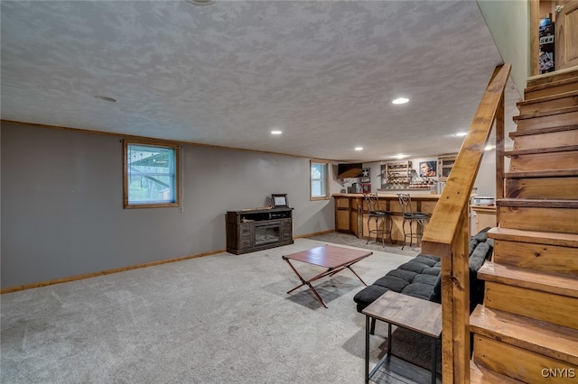 living room with a textured ceiling, light colored carpet, and indoor bar