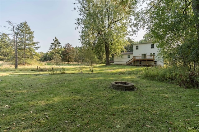 view of yard with a wooden deck and an outdoor fire pit