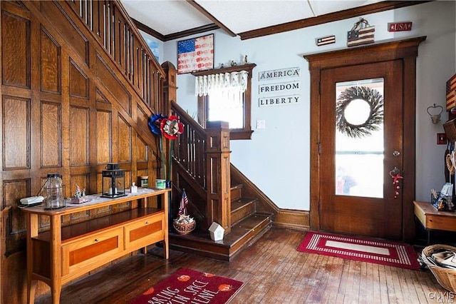 entrance foyer with hardwood / wood-style floors, a healthy amount of sunlight, and ornamental molding