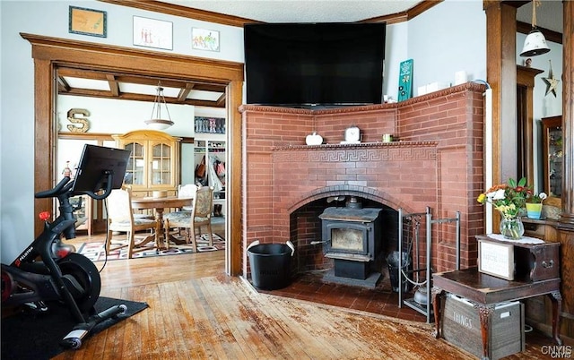 living room with wood-type flooring, a wood stove, and ornamental molding