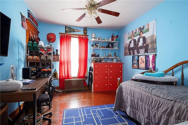 bedroom with ceiling fan, radiator heating unit, and dark wood-type flooring