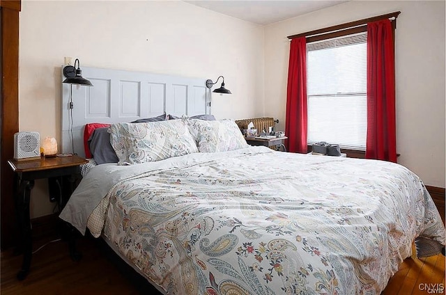 bedroom with dark hardwood / wood-style floors