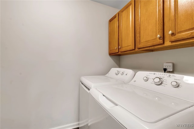 laundry room with washing machine and dryer and cabinets