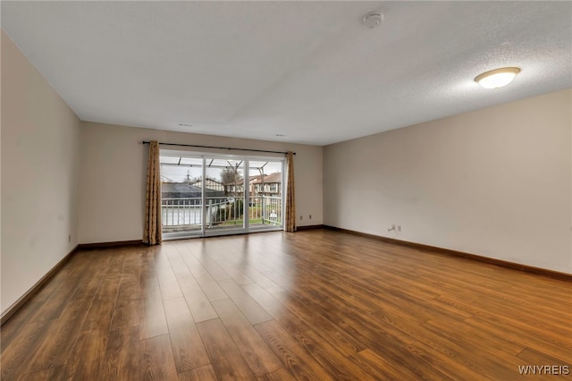 unfurnished room featuring hardwood / wood-style flooring and a textured ceiling