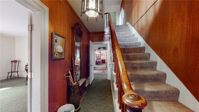 stairs with wood walls and carpet