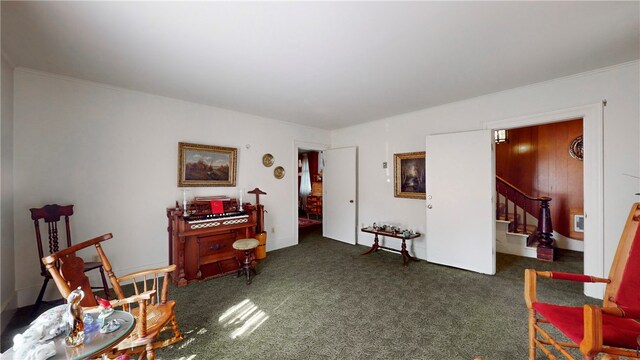 sitting room with crown molding and dark carpet