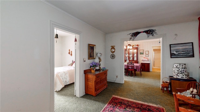 corridor featuring a chandelier, crown molding, and dark carpet