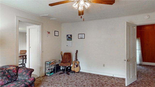 sitting room featuring ornamental molding, carpet, and ceiling fan