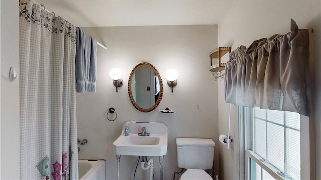 full bathroom with shower / bath combo with shower curtain, toilet, and sink