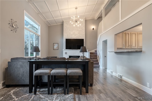 interior space featuring a fireplace, wood-type flooring, cream cabinetry, and lofted ceiling