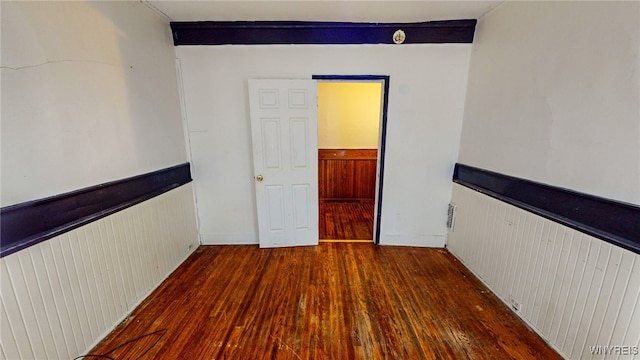 unfurnished room featuring dark hardwood / wood-style flooring and radiator