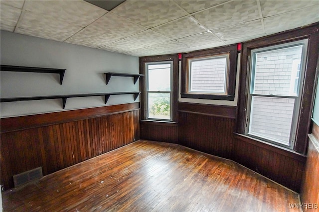 spare room with wood-type flooring and wooden walls