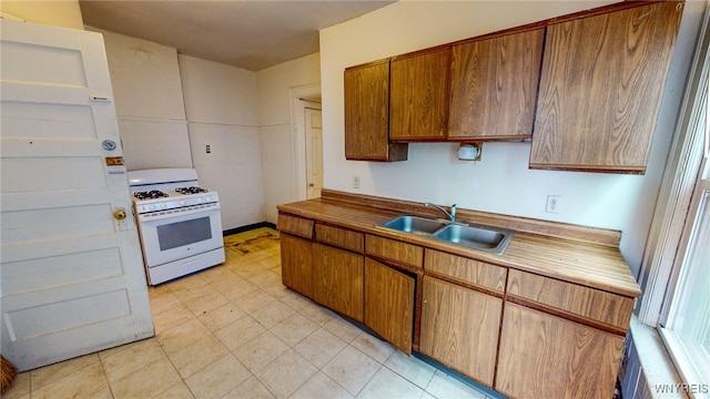 kitchen featuring white gas range and sink