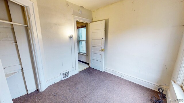 unfurnished bedroom featuring dark carpet