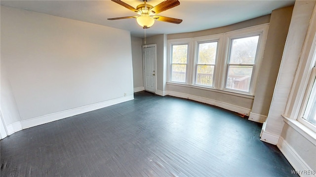 empty room with ceiling fan and dark wood-type flooring