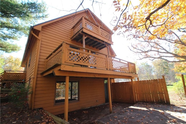 rear view of property with a deck and fence