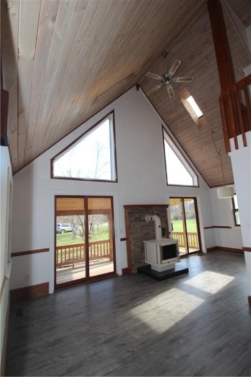 unfurnished living room featuring a wood stove, wooden ceiling, high vaulted ceiling, and dark wood-type flooring