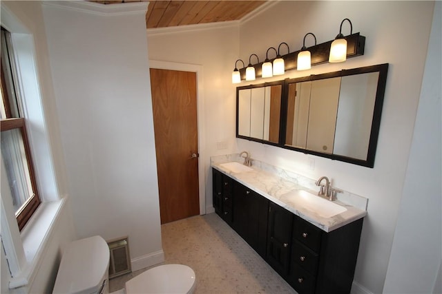 full bath with toilet, crown molding, double vanity, and a sink