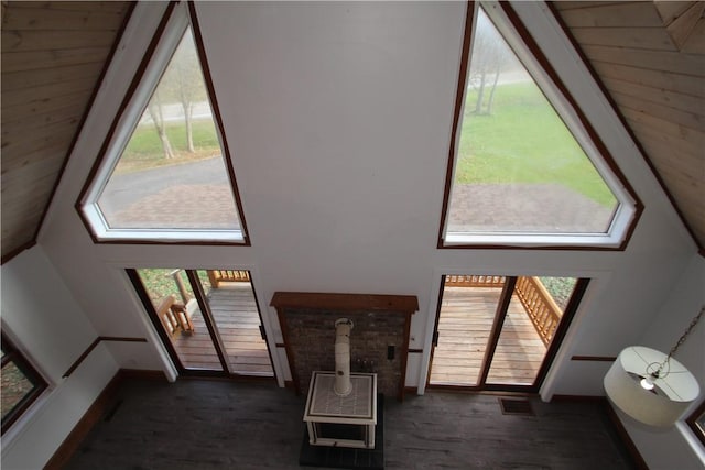 interior space featuring dark wood-style floors, baseboards, a high ceiling, and visible vents