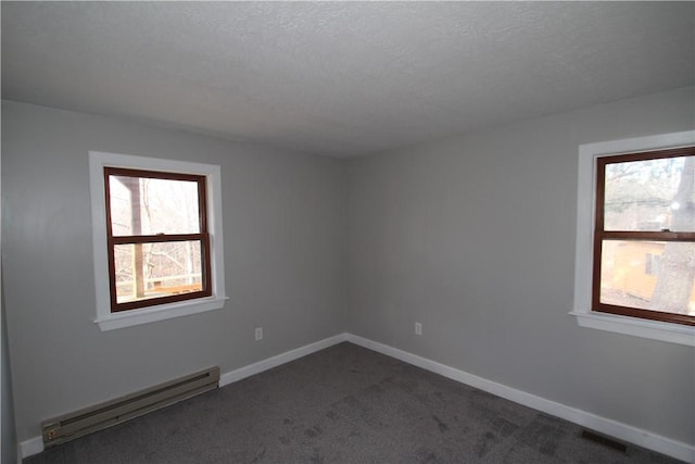 empty room with a baseboard radiator, baseboards, a textured ceiling, and dark colored carpet