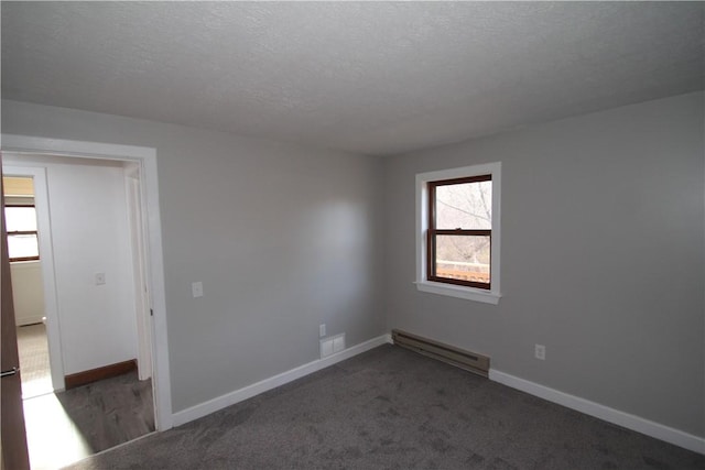 spare room with baseboards, a textured ceiling, and baseboard heating