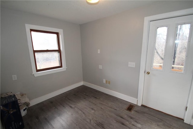 interior space featuring visible vents, baseboards, dark wood finished floors, and a wealth of natural light