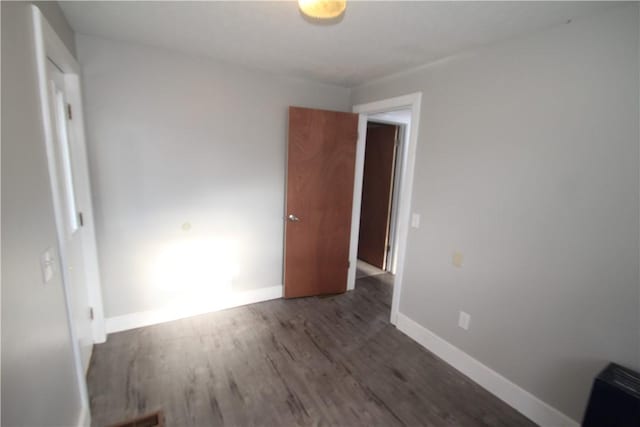 unfurnished bedroom featuring dark wood-style floors and baseboards