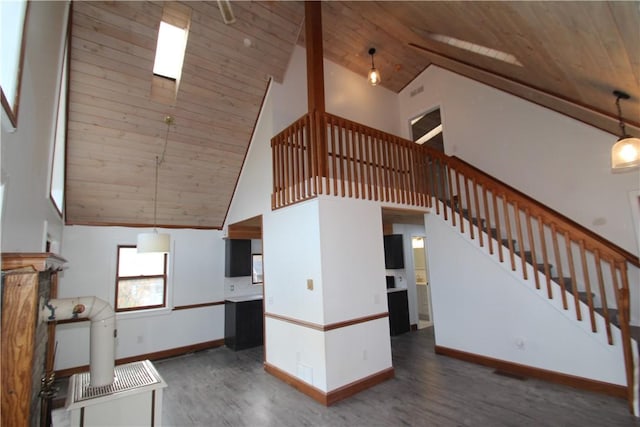 unfurnished living room featuring wooden ceiling, dark wood finished floors, stairway, and baseboards