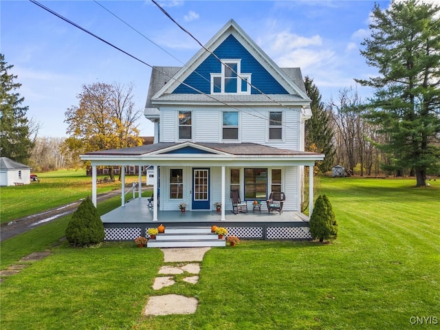 rear view of house with a lawn and a porch