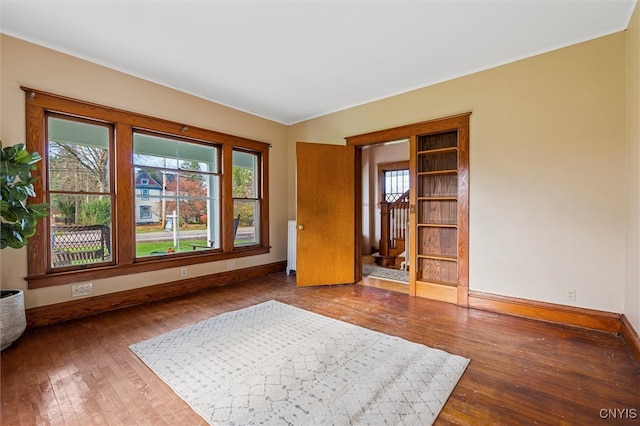 empty room featuring ornamental molding, hardwood / wood-style flooring, and radiator