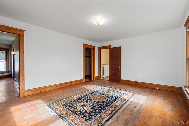 unfurnished room featuring hardwood / wood-style floors and radiator heating unit