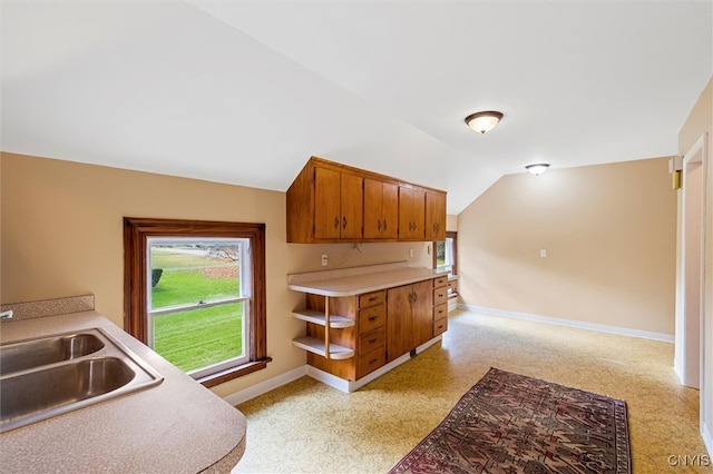 kitchen featuring light carpet, sink, and vaulted ceiling