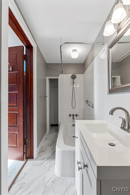 bathroom featuring vanity and tiled shower / bath