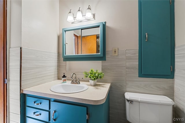 bathroom featuring vanity, tile walls, and toilet