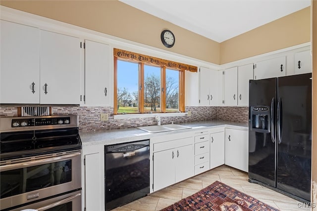 kitchen featuring sink, tasteful backsplash, white cabinetry, and black appliances