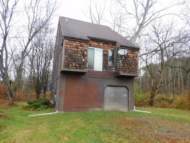 view of side of home featuring a yard and a garage