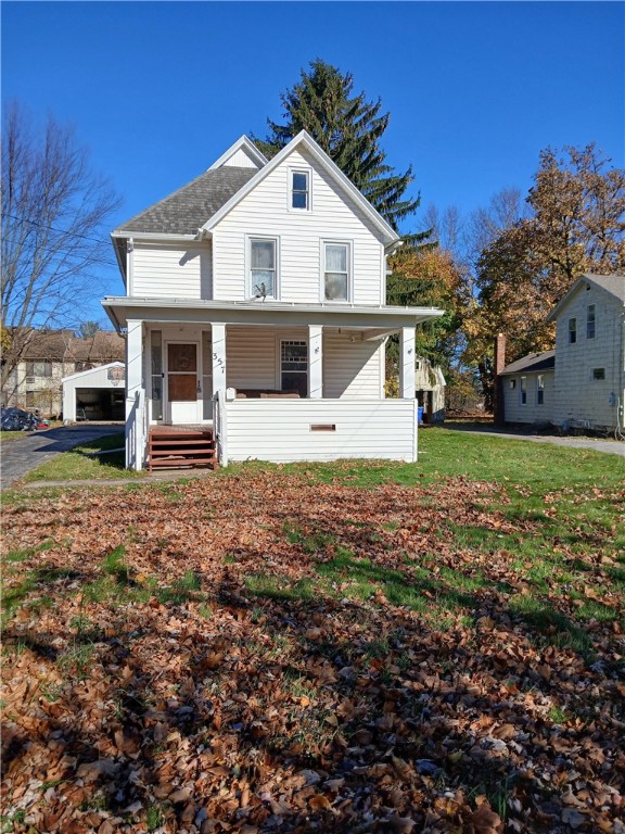 front facade featuring covered porch and a front lawn