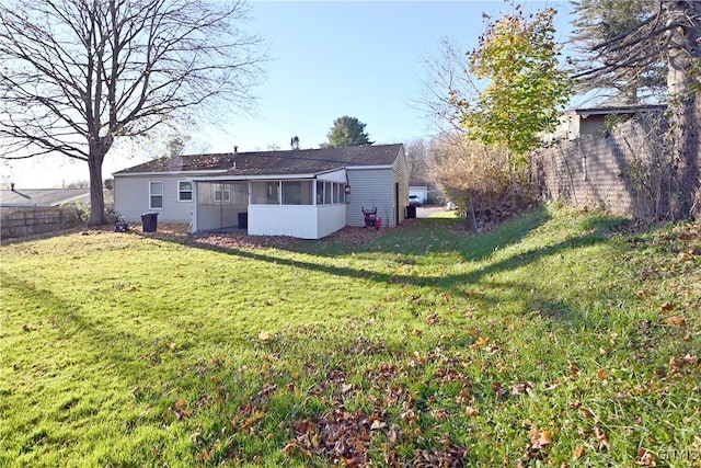 back of property featuring a lawn and a sunroom